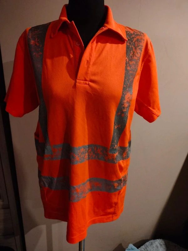 Koszulka ostrzegawcza po wielu praniach – zużyte i pokruszone taśmy odblaskowe niespełniające już funkcji widoczności